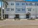 Charming row of townhomes, each featuring a private garage and unique coastal-inspired color schemes at 3138 Nautical S Pl, St Petersburg, FL 33712