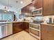 Gourmet kitchen featuring stainless appliances, granite counters, and dark wood cabinetry at 3138 Nautical S Pl, St Petersburg, FL 33712
