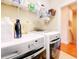 This laundry room has white washer and dryer and storage racks at 3138 Nautical S Pl, St Petersburg, FL 33712