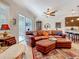 Cozy living area seamlessly blends with the kitchen, featuring a leather sofa, area rug, and modern ceiling fan at 3138 Nautical S Pl, St Petersburg, FL 33712