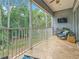 A screened patio with tranquil views of lush trees and an outdoor seating area at 3138 Nautical S Pl, St Petersburg, FL 33712