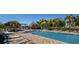 Sparkling community pool surrounded by lounge chairs and shady palm trees for a resort-like feel at 3138 Nautical S Pl, St Petersburg, FL 33712