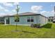 Rear exterior view featuring a well maintained yard and energy efficient air conditioning unit at 31647 Malbec Dr, Brooksville, FL 34602