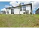 An exterior view of the home's backyard featuring a sliding door and lush green lawn at 31647 Malbec Dr, Brooksville, FL 34602