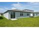 Backyard view of home with sliding glass door and green grass lawn at 31647 Malbec Dr, Brooksville, FL 34602