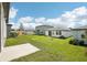 Spacious backyard with green lawn and view of neighboring homes under a partly cloudy sky at 31647 Malbec Dr, Brooksville, FL 34602