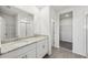 Bathroom featuring a double vanity with granite counters, a walk-in closet, and a glass-enclosed shower at 31647 Malbec Dr, Brooksville, FL 34602