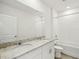 Bright bathroom with dual sinks, granite counters, and a shower-tub combination at 31647 Malbec Dr, Brooksville, FL 34602