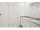 Well-lit bathroom features double sinks, granite countertops, white cabinets and walk-in shower at 31647 Malbec Dr, Brooksville, FL 34602