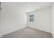 Bright bedroom features neutral carpeting, a single window, and fresh white walls at 31647 Malbec Dr, Brooksville, FL 34602