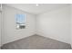 Bright bedroom features a window, neutral carpet, and white walls, awaiting personal touches at 31647 Malbec Dr, Brooksville, FL 34602