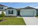Charming single-Gathering home featuring a two-car garage, manicured lawn, and stone accents at 31647 Malbec Dr, Brooksville, FL 34602