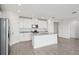 Bright, modern kitchen with white cabinets, granite counters, stainless appliances, and an island with a sink at 31647 Malbec Dr, Brooksville, FL 34602