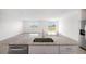 Kitchen island featuring a sink and a view into a sunlit dining/living area with sliding glass doors at 31647 Malbec Dr, Brooksville, FL 34602