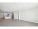 Open-concept living space with white walls, tile flooring, and a partial kitchen view at 31647 Malbec Dr, Brooksville, FL 34602