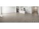 Spacious living room featuring wood-look tile floors leading to the kitchen at 31647 Malbec Dr, Brooksville, FL 34602