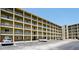 Exterior view of a multi-story condo building with multiple units, parking lot, and balconies in a light color scheme at 3534 Lake Bayshore Dr # 118, Bradenton, FL 34205