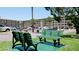 Scenic view of the complex's parking area and green benches, surrounded by palm trees at 3534 Lake Bayshore Dr # 118, Bradenton, FL 34205