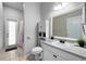 Bathroom with a sink vanity, toilet, large mirror, and a glass door leading to the outside at 3703 Treeline Dr, Valrico, FL 33596