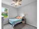 Bright bedroom with a striped bed, neutral walls, carpeted floors, ceiling fan, and a window at 3703 Treeline Dr, Valrico, FL 33596