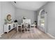 Bright dining room featuring wood floors, a modern white table set, a large window, and light gray paint at 3703 Treeline Dr, Valrico, FL 33596