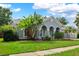 Charming single-story home featuring arched entrance, blue paint, lush landscaping, and a well-manicured lawn at 3703 Treeline Dr, Valrico, FL 33596