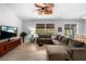 Bright living room featuring light wood floors, ceiling fan, and a large sofa at 3703 Treeline Dr, Valrico, FL 33596