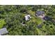 Aerial view showcasing two homes on a verdant, tree-lined property with a trampoline and well-maintained lawns at 37309 Fountain Rd, Zephyrhills, FL 33542