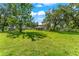 Well-manicured lawn with mature trees creating a serene backdrop for the charming two-story home at 37309 Fountain Rd, Zephyrhills, FL 33542