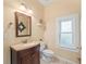 Bathroom featuring wooden vanity with solid surface top, window, and framed mirror at 37309 Fountain Rd, Zephyrhills, FL 33542
