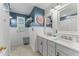 Updated bathroom with double vanity, framed mirrors, tub/shower, and wainscotting at 37309 Fountain Rd, Zephyrhills, FL 33542