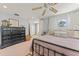 Spacious bedroom boasts dresser, a round window, ceiling fan and natural light at 37309 Fountain Rd, Zephyrhills, FL 33542