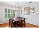 Formal dining room with hardwood floors, large windows, and a stylish chandelier above the dining table at 37309 Fountain Rd, Zephyrhills, FL 33542