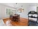 Bright dining room features hardwood floors, chandelier, and large window with natural light at 37309 Fountain Rd, Zephyrhills, FL 33542