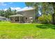 Rear view of a two-story home featuring a metal roof, screened porch, and an outdoor patio area at 37309 Fountain Rd, Zephyrhills, FL 33542