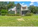 Charming two-story home with a metal roof, a screened-in porch, and a beautiful, well-maintained front yard at 37309 Fountain Rd, Zephyrhills, FL 33542