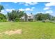 Charming two-story home with a metal roof, a screened-in porch, and a large, well-maintained front yard at 37309 Fountain Rd, Zephyrhills, FL 33542