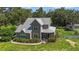 Charming two-story home with a metal roof, a screened-in porch, and a beautiful, well-maintained front yard at 37309 Fountain Rd, Zephyrhills, FL 33542