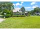 Charming two-story home with a metal roof, a screened-in porch, and a large, well-maintained front yard at 37309 Fountain Rd, Zephyrhills, FL 33542