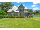 Charming two-story home with a metal roof, a screened-in porch, and a beautiful, well-maintained front yard at 37309 Fountain Rd, Zephyrhills, FL 33542