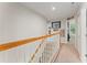 Hallway with wood railing and framed pictures on the wall at 37309 Fountain Rd, Zephyrhills, FL 33542