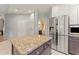 Modern kitchen featuring stainless steel appliances, a center island, and access to a bathroom at 37309 Fountain Rd, Zephyrhills, FL 33542