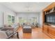 Bright living room with hardwood floors, comfortable seating, and natural light from large windows at 37309 Fountain Rd, Zephyrhills, FL 33542
