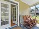 Inviting front porch featuring rocking chairs, a welcome sign, and double doors leading into the home at 37309 Fountain Rd, Zephyrhills, FL 33542