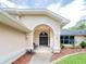Inviting front entrance with an elegant arched entryway and well-maintained landscaping at 382 Florian Way, Spring Hill, FL 34609