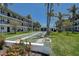 Community lawn with shuffleboard court framed by palm trees and white buildings under a blue sky at 4050 4Th N St # 205, St Petersburg, FL 33703