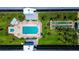 An aerial view of the community pool, shuffleboard court and deck area surrounded by lush landscaping at 4050 4Th N St # 205, St Petersburg, FL 33703