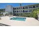 Community pool area with a hot tub, palm trees, and chaise lounges at 4050 4Th N St # 205, St Petersburg, FL 33703
