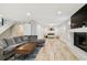 Open basement area with a fireplace, gray sectional, wood floors, and playroom at 4203 W Cleveland St, Tampa, FL 33609