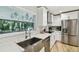Kitchen featuring stainless steel appliances, quartz counters, white cabinets, and decorative light fixtures at 4203 W Cleveland St, Tampa, FL 33609